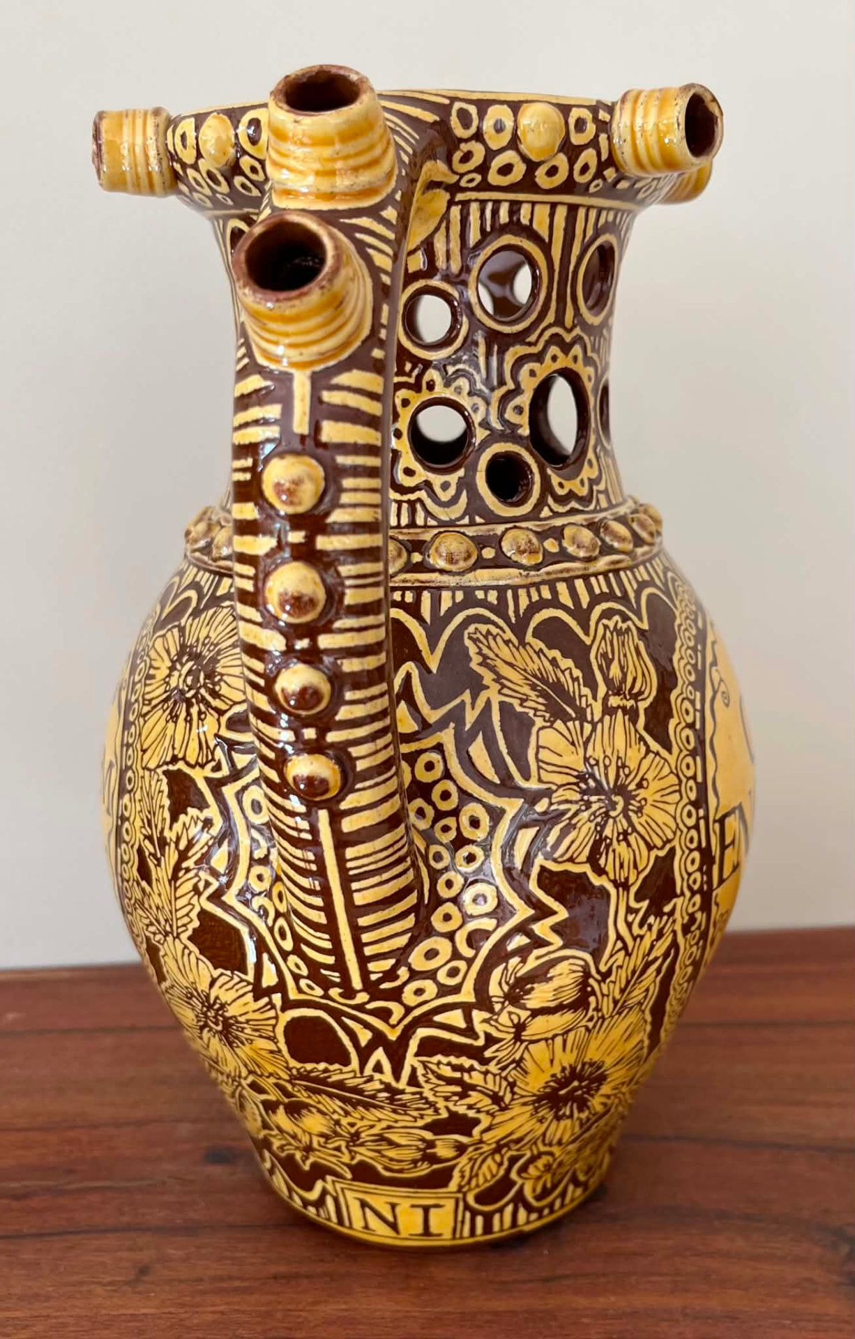 Reverse view of the finished puzzle jug showing its decorated handle and floral carving.
